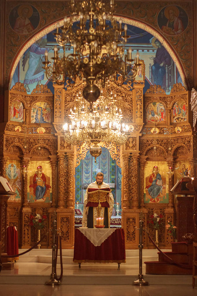 Платамонас, Греція - 31 жовтня 2018: Православний батюшка читання Святого Писання під час обслуговування зцілення - Фото, зображення