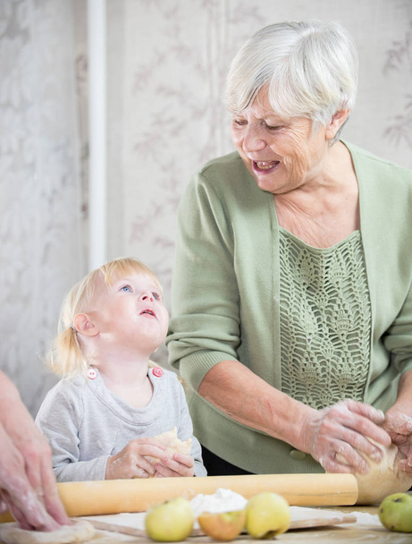 Una nonna che fa piccole torte con una bambina
. - Foto, immagini