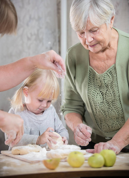 Бабуся робить маленькі пироги зі своєю онукою
. - Фото, зображення
