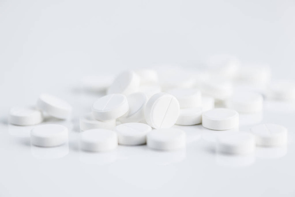 Close up tiro de pílulas brancas quebráveis no fundo branco, espaço de cópia
 - Foto, Imagem