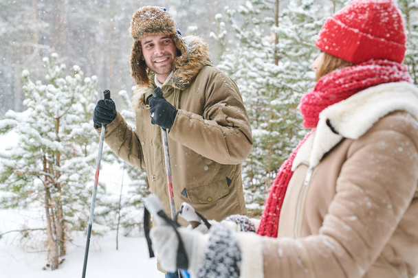 Портрет активної молодої пари, яка насолоджується катанням на лижах у засніженому зимовому парку, зосереджується на людині, яка любить дивитися на свою дівчину, копіювати простір
 - Фото, зображення