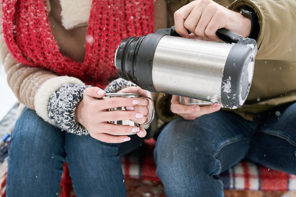Close up of unrecognizable young couple enjoying hot cocoa during date in winter outdoors - Φωτογραφία, εικόνα