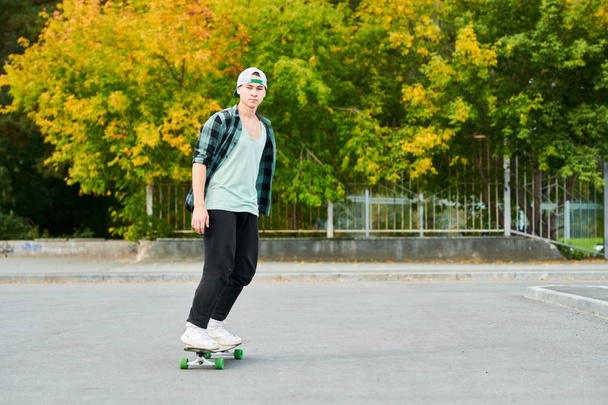 Portrait complet de jeune homme contemporain chevauchant le skateboard à l'extérieur dans un parc extrême, espace de copie
 - Photo, image