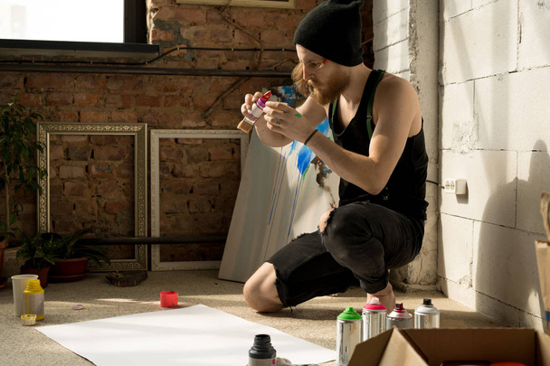 Vue de côté portrait complet de l'artiste contemporain inspiré croquis photo avec crayon sur le sol dans un studio d'art, espace de copie
 - Photo, image