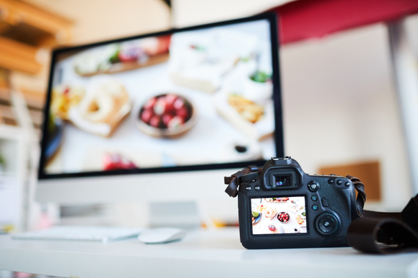 Immagine di sfondo della macchina fotografica con foto di cibo sul tavolo contro computer con software di editing, spazio di copia
 - Foto, immagini