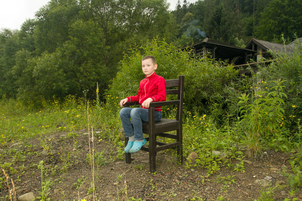 Garçon assis sur une chaise dans la forêt
 - Photo, image