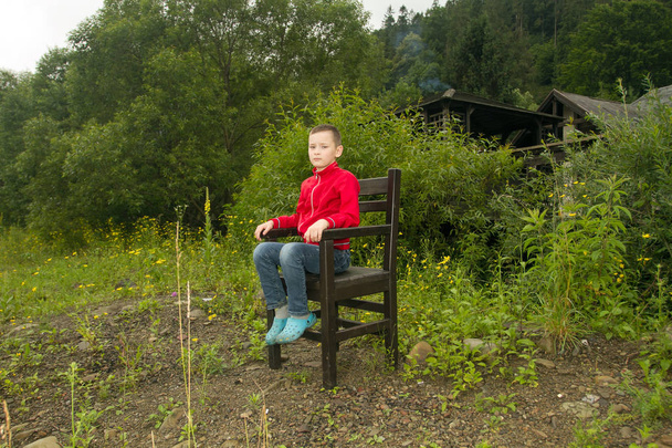 Boy Sitting on Chair in the Forest - Photo, Image