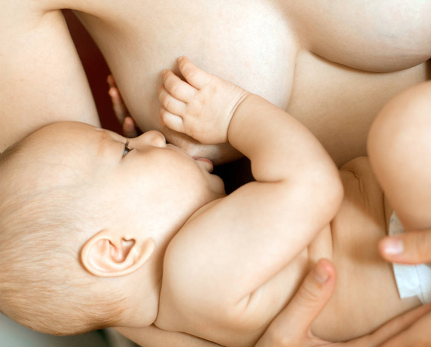 Мати годує грудьми дитину
 - Фото, зображення