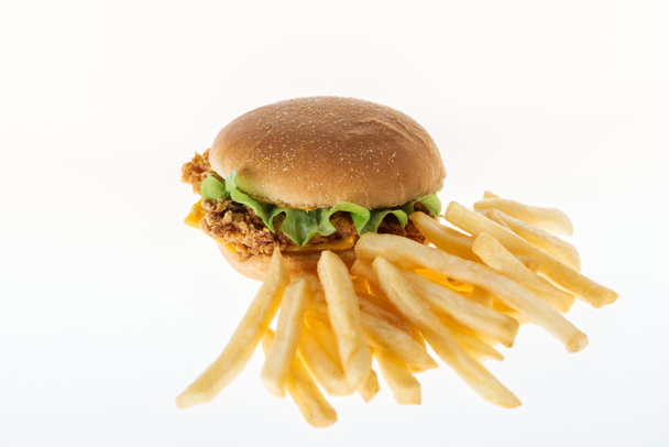 tasty unhealthy chicken burger near french fries isolated on white - 写真・画像