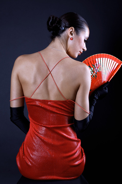 Back latino woman with red fan - Foto, afbeelding