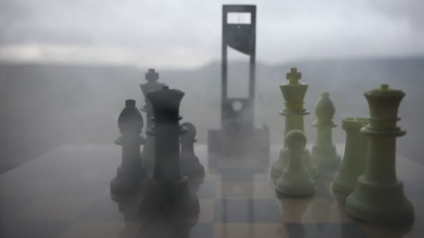 schaakbord spel concept van zakelijke ideeën en concurrentie en strategie ideeën. Schaakfiguren op een schaakbord op mist achtergrond. Selectieve focus - Video