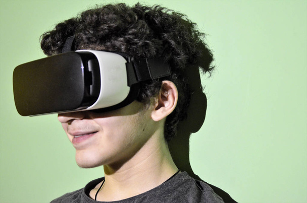 Um jovem caucasiano usa o visualizador VR 360 em seu quarto
 - Foto, Imagem
