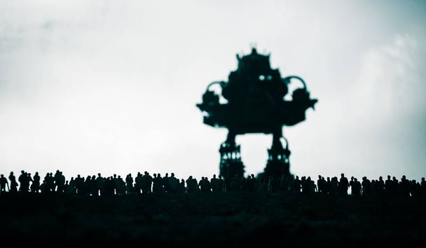 Decorazione d'arte. Silhouette di robot gigante preparare folla attacco al tramonto. Vista orrenda del cyborg futuristico che attacchera 'persone spaventate. Focus selettivo
. - Foto, immagini