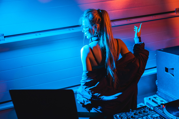  atractivo rubia dj mujer gesto mientras de pie en nightclub
 - Foto, Imagen