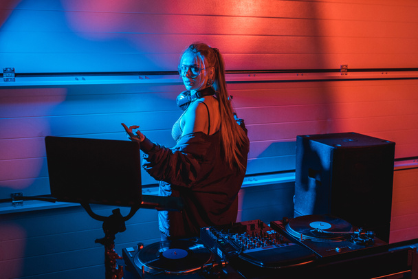  beautiful blonde dj woman gesturing while standing in nightclub - Foto, afbeelding