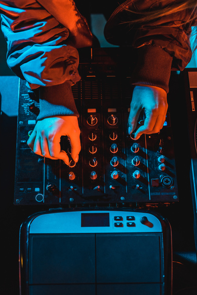 top view of dj woman touching dj mixer in nightclub - Foto, Bild