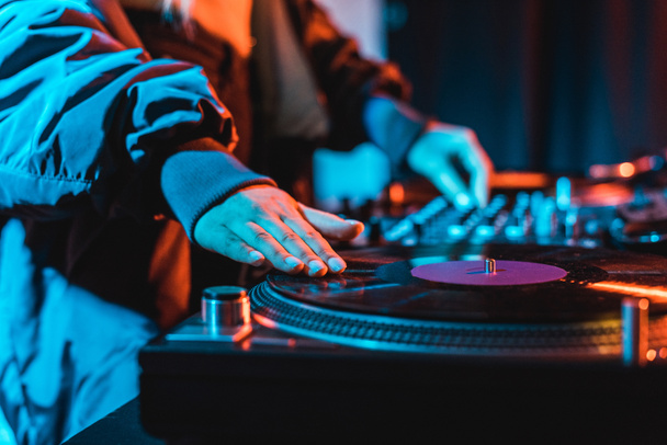 selective focus of dj woman touching vinyl record in nightclub - Photo, Image
