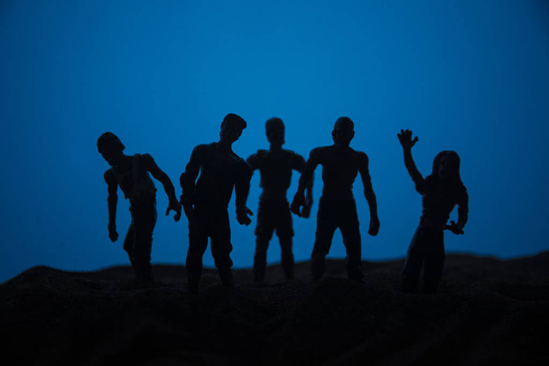 Concepto de Halloween de horror. Siluetas de zombies aterradores en el campo brumoso caminando por la noche. Enfoque selectivo. Decoración creativa de obras de arte
 - Foto, Imagen