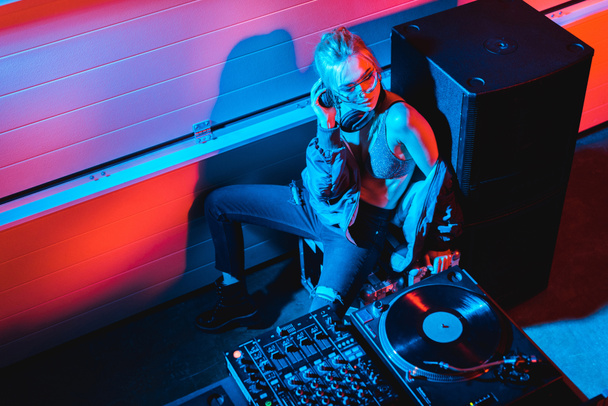 vista aerea di dj ragazza con i capelli biondi seduto vicino a dj attrezzature in discoteca
 - Foto, immagini