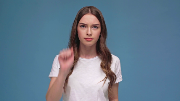 bela menina fazendo bater gesto batida e olhando para a câmera isolada no azul
 - Filmagem, Vídeo