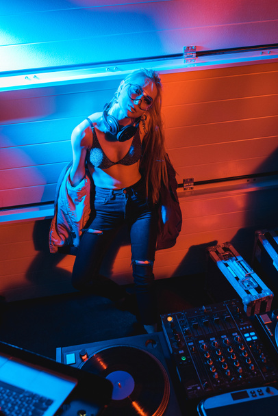 atraente loira dj menina de pé perto dj mixer no clube noturno
 - Foto, Imagem