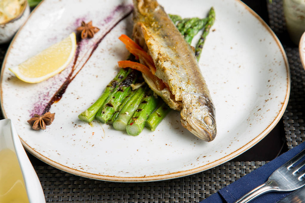 Fried fish with appetizers and white wine. Caucasian cuisine. - 写真・画像