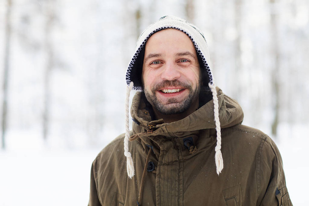 Waist up portrait of mature bearded man in winter forest looking at camera and smiling, copy space - Φωτογραφία, εικόνα