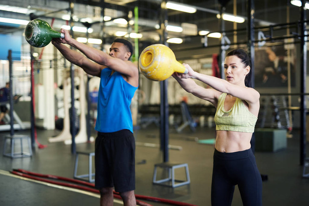 Dva mladí sportovci v aktivování při práci ve fitness centru - Fotografie, Obrázek