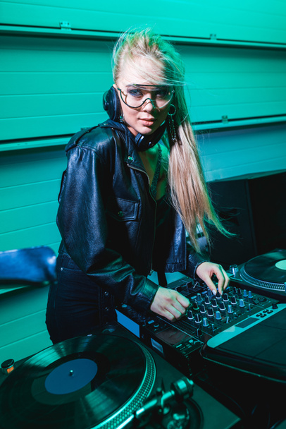 ξανθιά dj κορίτσι με τα γυαλιά που αγγίζουν Μείκτης dj σε νυχτερινό κέντρο διασκέδασης  - Φωτογραφία, εικόνα