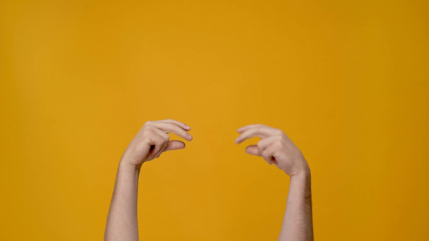 oříznutý pohled člověka prsty izolované na žluté - Záběry, video