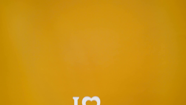 cropped view of man presenting love sign isolated on yellow - Footage, Video