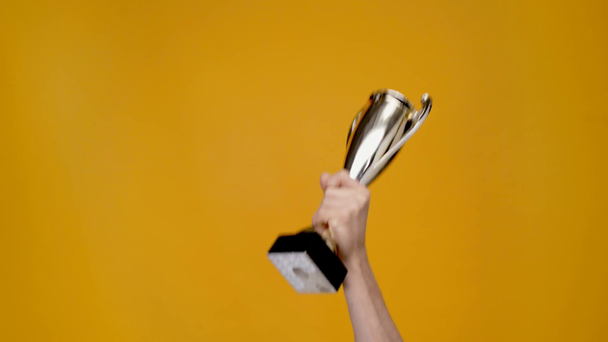 vista recortada del hombre que presenta copa trofeo aislado en amarillo con espacio de copia
 - Imágenes, Vídeo