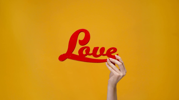 bijgesneden beeld van vrouw presentatie van rode liefde teken geïsoleerd op geel - Video