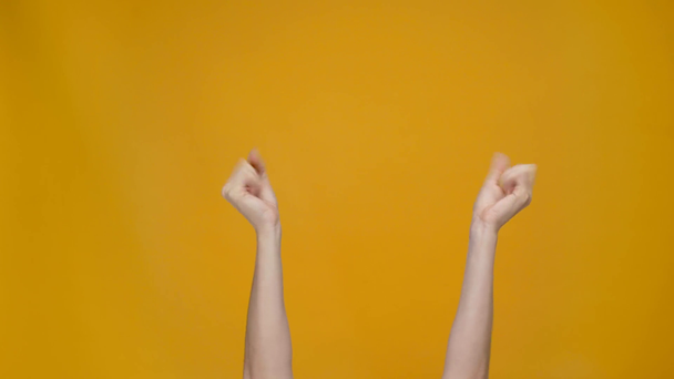 vista cortada da mulher cruzando os dedos, fazendo por favor gesto e mostrando punhos apertados isolados no amarelo
 - Filmagem, Vídeo