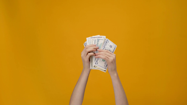 vista recortada de la mujer contando billetes de dólar en manos aisladas en amarillo
 - Imágenes, Vídeo