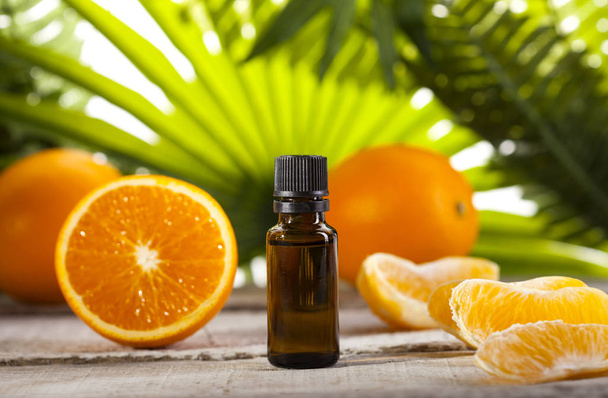 Orange Essential Oil on green leaves background - Foto, Bild