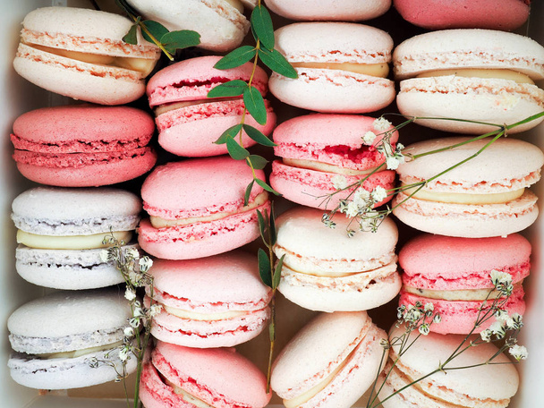 Colorful French or Italian macarons stack on white wood table with copy space for background. Dessert for served with afternoon tea or coffee break. - Photo, Image