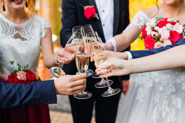 Newlyweds and friends clang their glasses with champagne  - Foto, immagini