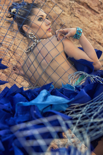 niña en vestido azul con cadenas y malla metálica
 - Foto, imagen