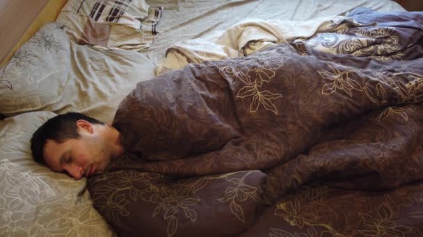 Hombre durmiendo y despertando solo en la cama, cerca de la cara. Cabeza de adulto caucásico hombre de 30 años con la cabeza en la almohada por la mañana
. - Metraje, vídeo