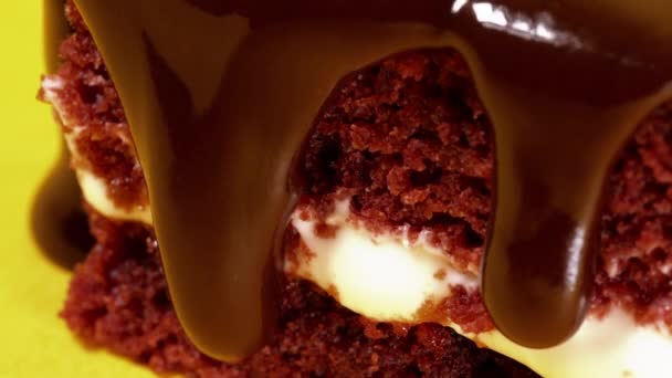 Chocolade Topping glazuur gieten op biscuit cake dessert op gele achtergrond. Close-up van zoete decoratie. Koken, eten en bakken, banketbakkerij concept. - Video