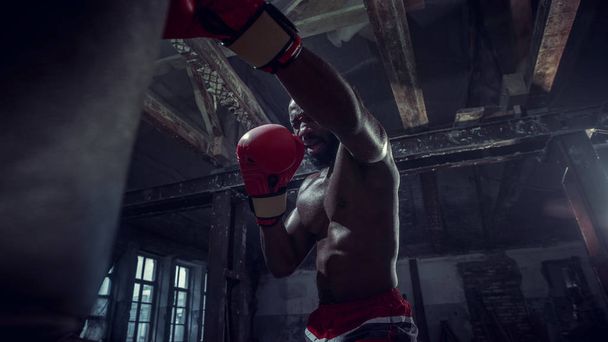 Hand eines Boxers über schwarzem Hintergrund. Kraft, Angriff und Bewegungskonzept - Foto, Bild