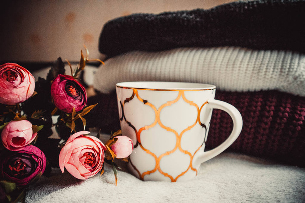 Taza de café, suéteres y flores sobre fondo de cuadros suaves - Foto, imagen