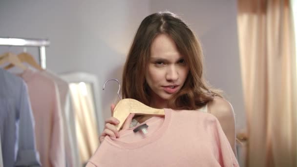 Sensual woman choosing dress. Pretty girl trying clothes at home studio - Filmagem, Vídeo