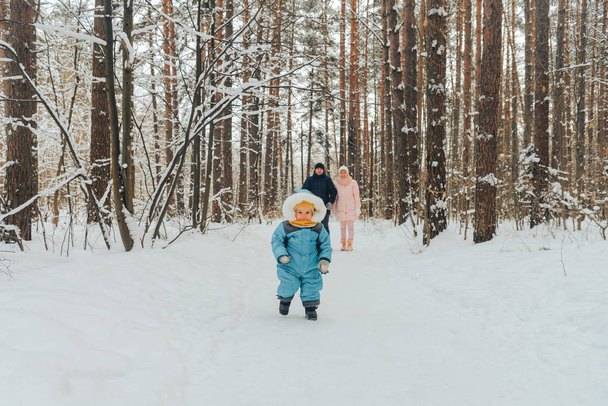 Walking family with a child. Family walks in nature in winter. Winter family walk in nature. A lot of snow. - Zdjęcie, obraz