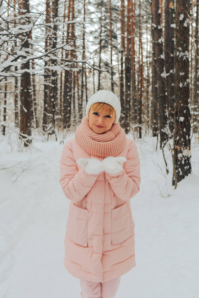Vrouw wandelingen in het bos van de winter. Portret van de vrouw op de achtergrond van het winter-bos. - Foto, afbeelding