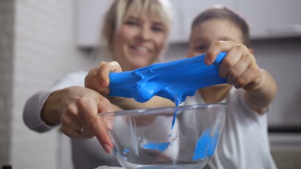 Closeup kids handen uitrekken selfmade blauwe slime - Video