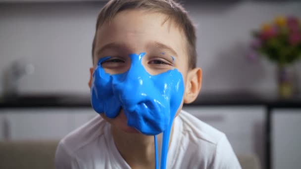 Adorable chico divertido con la cara cubierta de limo azul
 - Imágenes, Vídeo