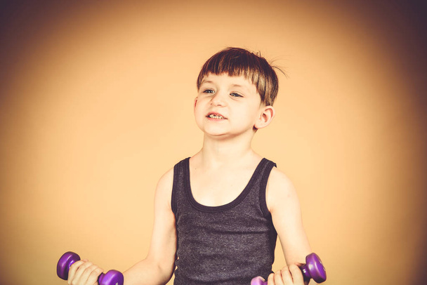 Το αγόρι που πηγαίνει σε για σπορ με αλτήρες, σωματική άσκηση και σε ένα νεαρό σώμα - Φωτογραφία, εικόνα