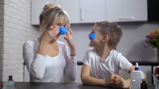 freudige Mutter und Sohn kleben handgemachten Schleim ins Gesicht - Filmmaterial, Video